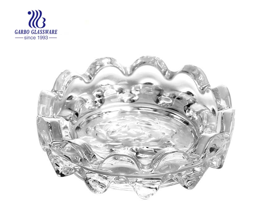 Clear glass ashtray with foundation and grooves for living room