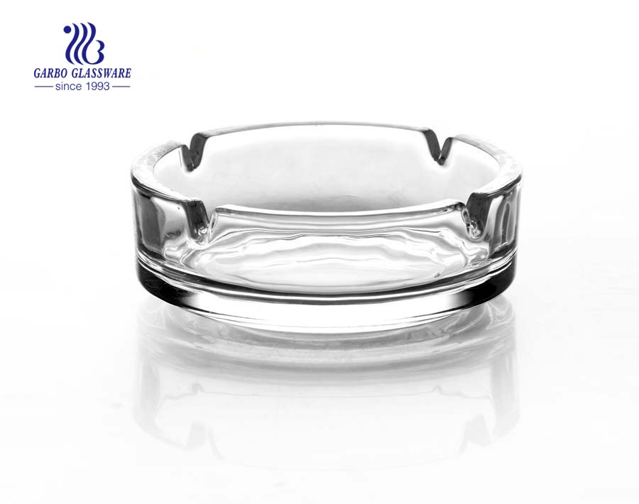 Clear glass ashtray with foundation and grooves for living room