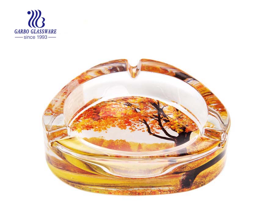 Clear glass ashtray with foundation and grooves for living room