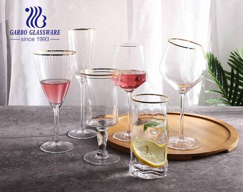 Conjunto de taças e copos de vidro luxuosos e sofisticados de borda dourada para a hora do jantar